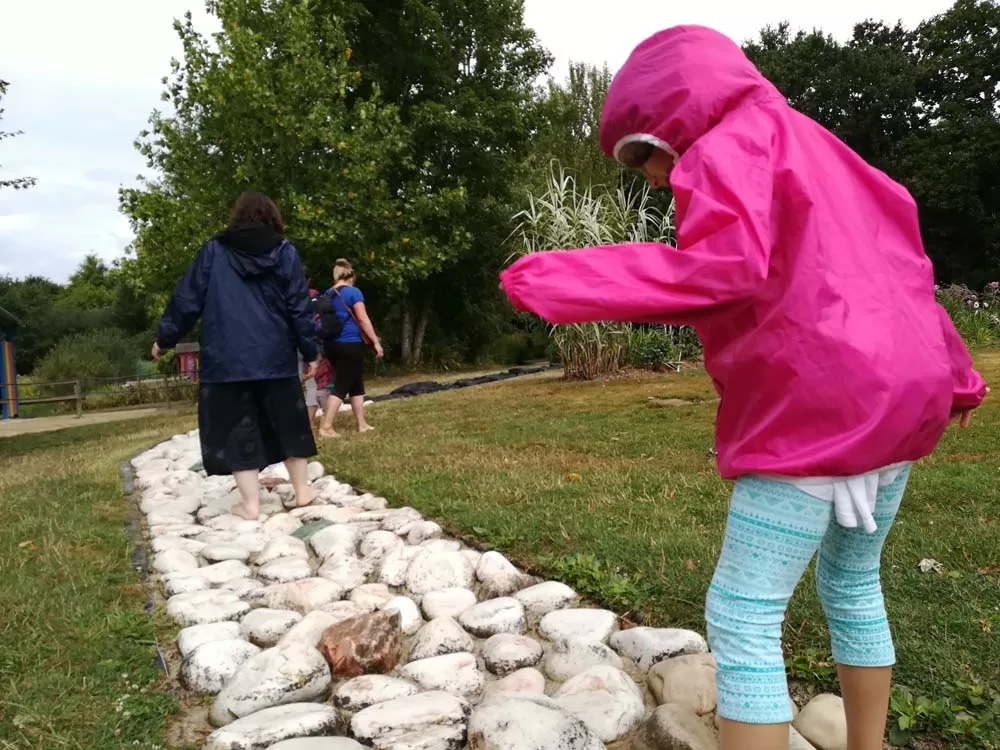 Vale e Irene sui sassi nel persorso sensoriale dei Brocéliande Gardens